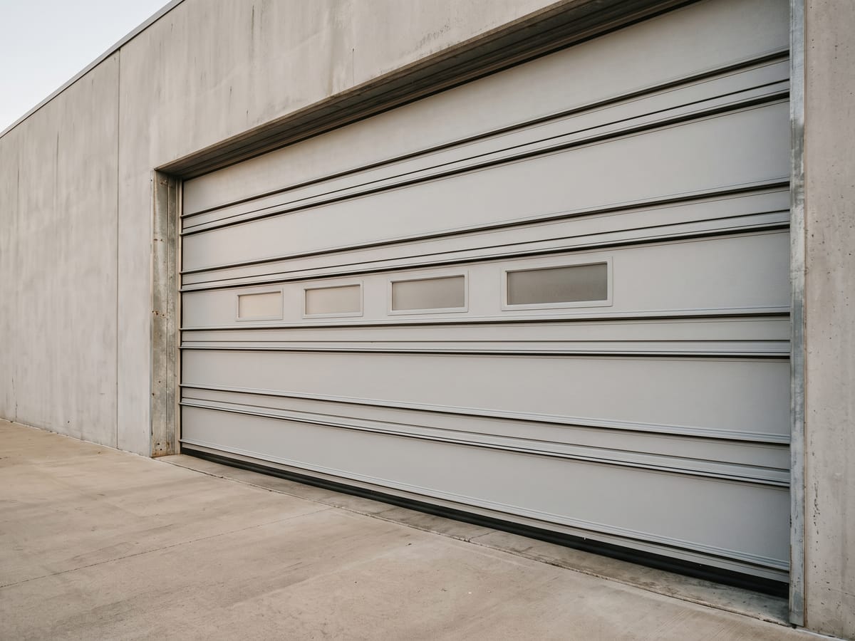 Large insulated steel sectional door with clean panel lines on a commercial service bay